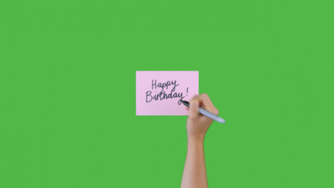 Woman-Writing-Happy-Birthday-In-Cursive-on-Paper-with-Green-Screen